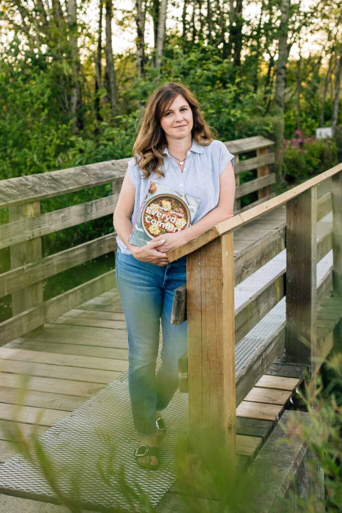 Holly Nilsson from Spend with Pennies holding her cookbook Everyday Comfort